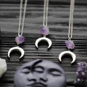 Amethyst crescent moon necklace in the Smooth Crescent design, showing variations in the purple crystals.