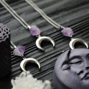 Amethyst crescent moon necklace in the Smooth Crescent design, arranged diagonally.