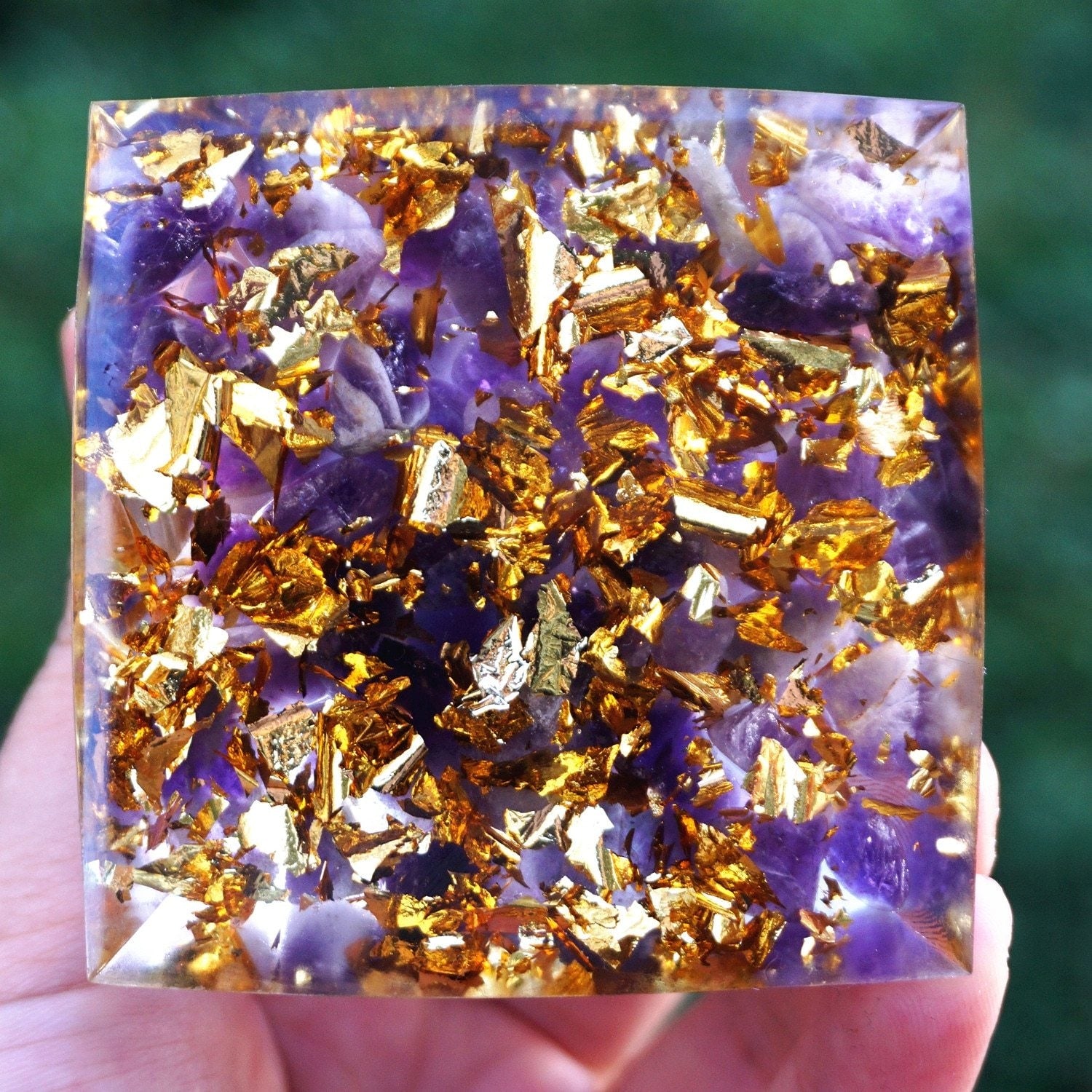 Purple amethyst pieces and bright gold-tone flecks fill the square underside of the lotus pyramid.