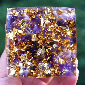 Purple amethyst pieces and bright gold-tone flecks fill the square underside of the lotus pyramid.