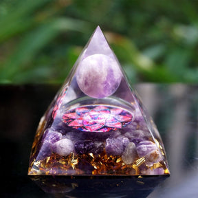 Front view of the amethyst pyramid on wood, with the lotus petals visible below the purple sphere.