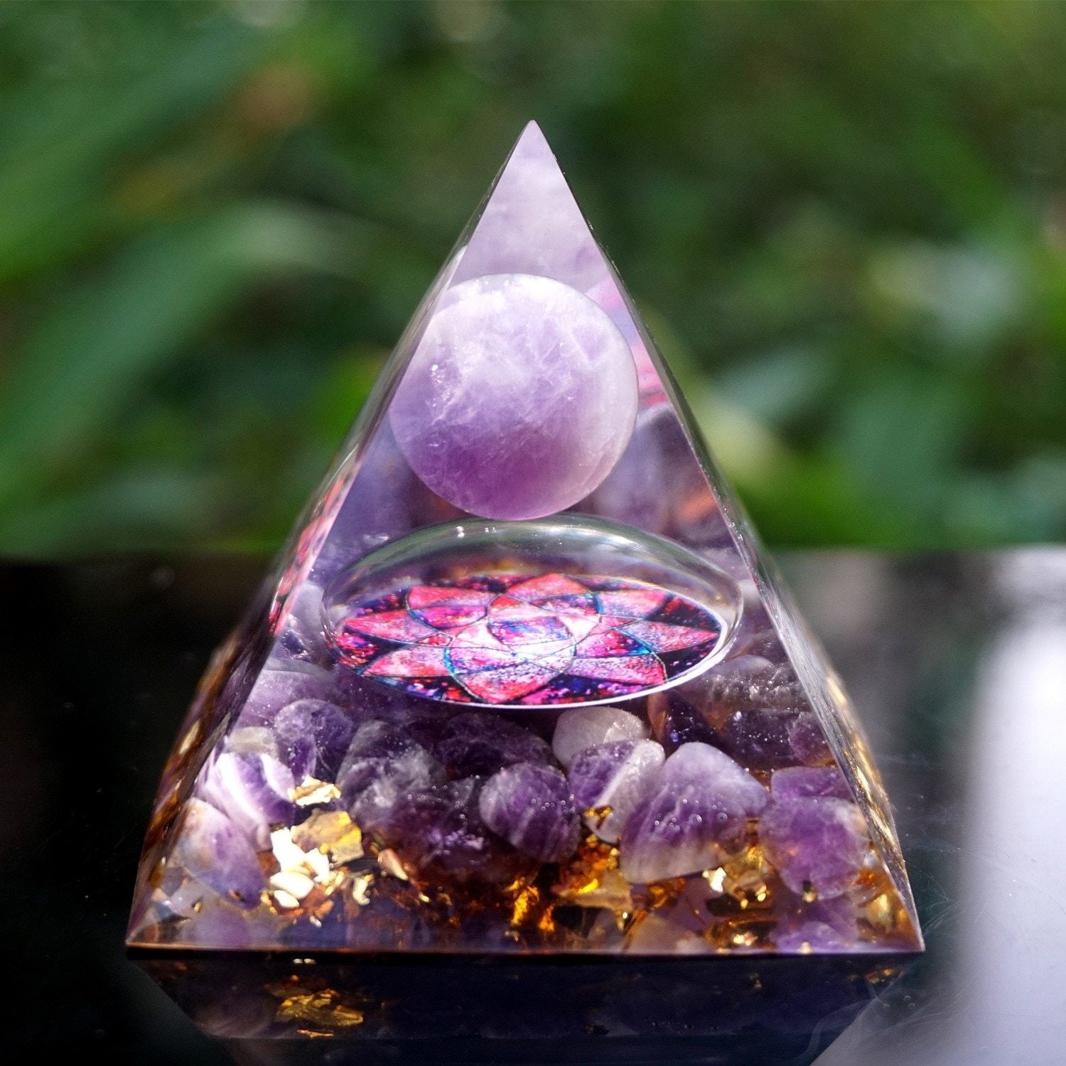 Amethyst lotus pyramid standing on wood, showing the clear pointed outline, purple sphere and layered flower design.