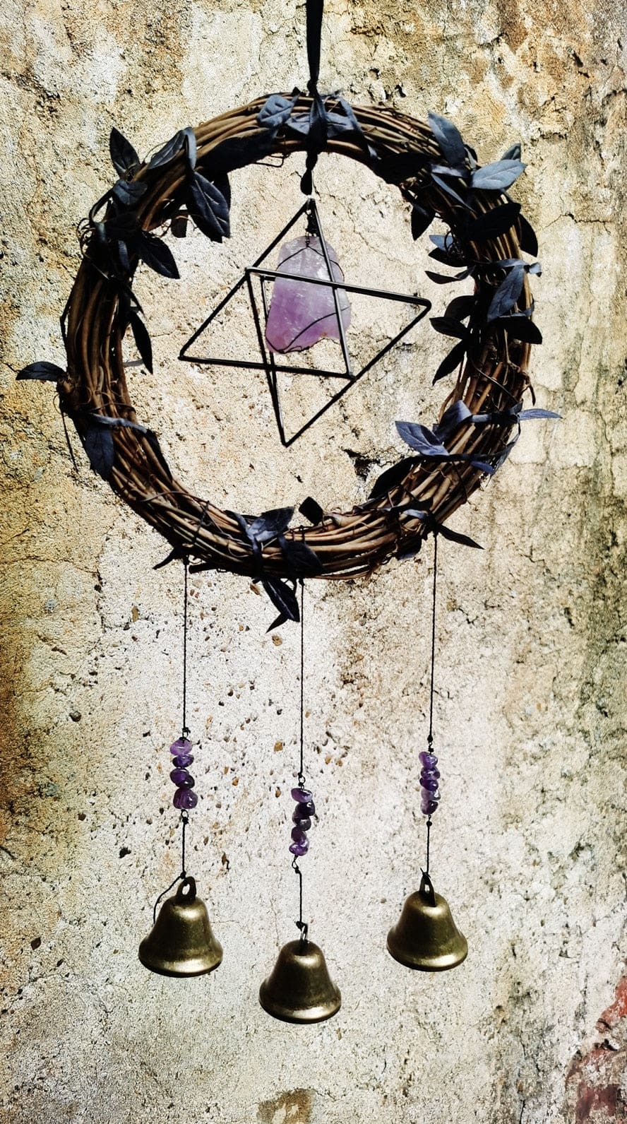 Amethyst wreath chimes against brick wall
