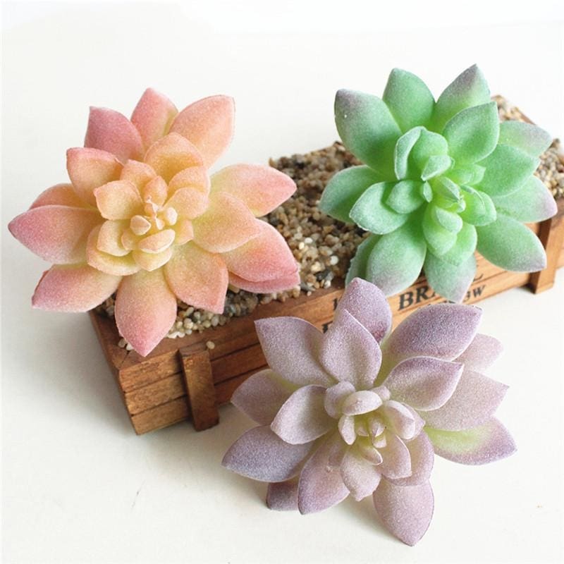 Three pastel artificial succulent rosettes displayed together, showing peach, lilac and pale green pointed leaves.