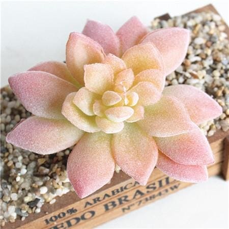 Peach-pink artificial succulent with pointed leaves arranged in a compact rosette above a short stem.