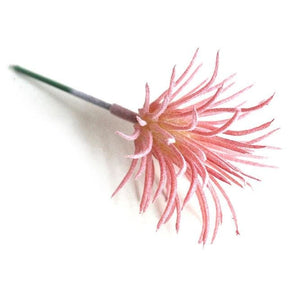 Pink artificial succulent with fine pointed leaves forming a small bushy head.