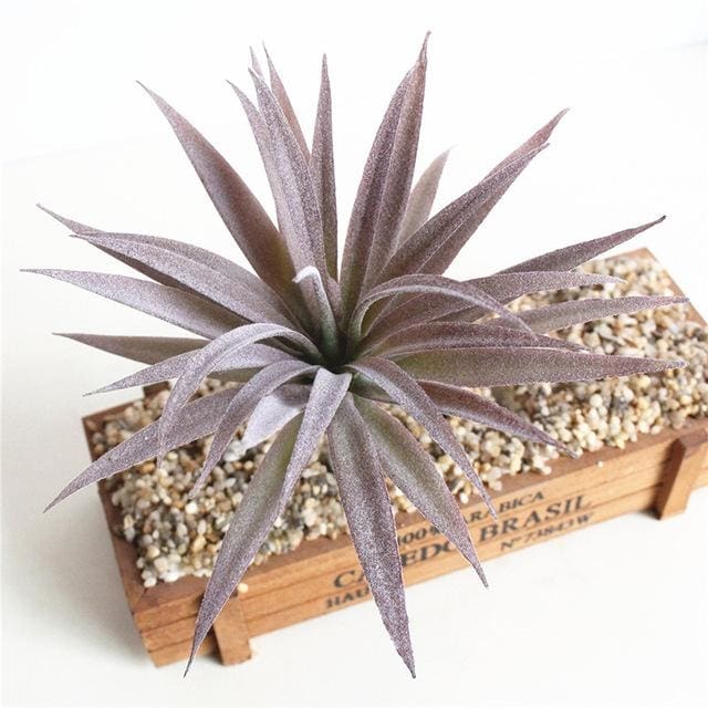 Purple artificial succulent with pointed leaves arranged in a spiky rosette.