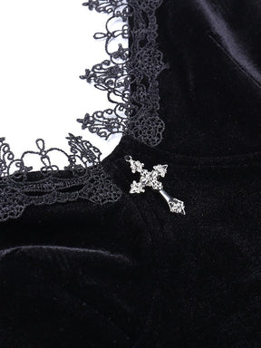 Silver-tone cross detail at the center of the black velour dress neckline, bordered by looped floral lace.