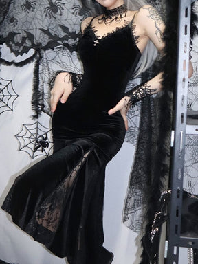 Angled view of the black velour dress with a raised knee and hands on the hips. Sheer floral lace shows between the opaque skirt panels.