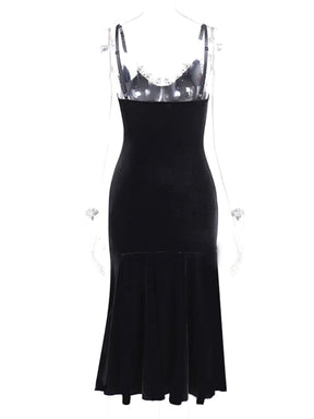 Back view of the black velour dress on a clear mannequin, showing its straight low back and plain black flared skirt.