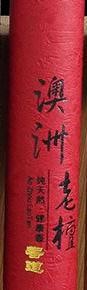 Close view of the red Australian sandalwood incense tube, showing its black lettering and gold accents.
