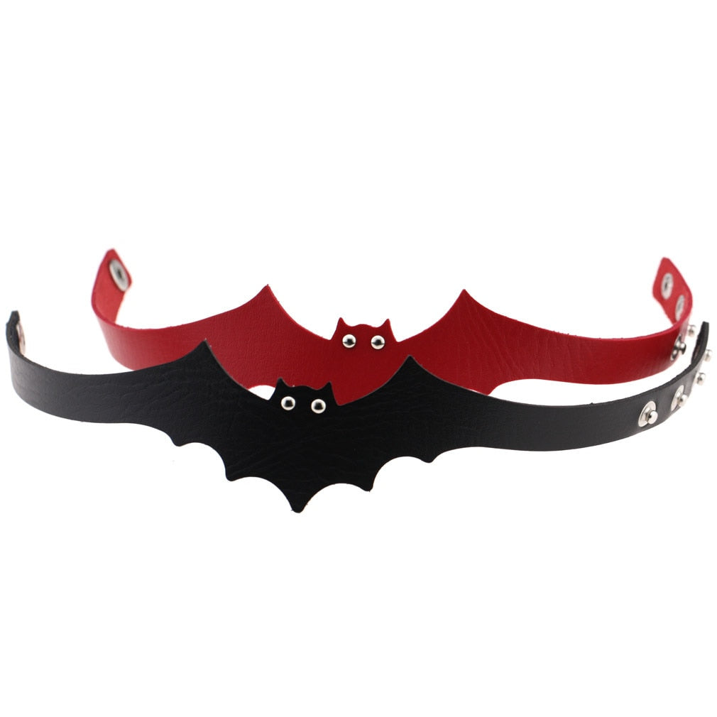 Black and red bat chokers stand open in an overlapping front view. Small eyelets form the eyes above the scalloped wing edges.