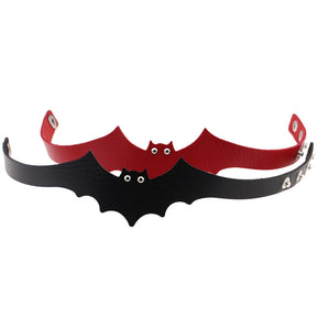 Black and red bat chokers stand open in an overlapping front view. Small eyelets form the eyes above the scalloped wing edges.
