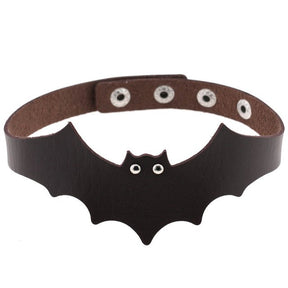 Dark brown faux leather bat wing choker shown fastened in a circle, with a scalloped front, pointed ears and two silver-tone eyelet eyes. The adjustable snap positions are visible across the back.