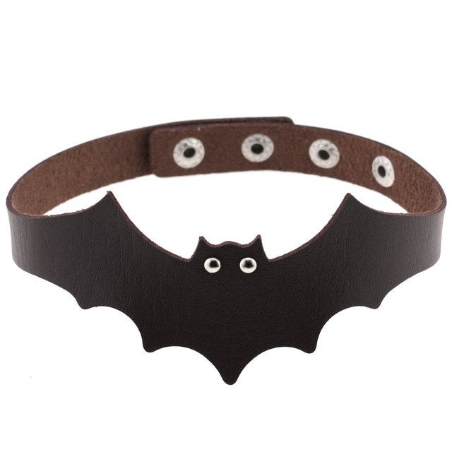 Dark brown faux leather bat wing choker shown fastened in a circle, with a scalloped front, pointed ears and two silver-tone eyelet eyes. The adjustable snap positions are visible across the back.