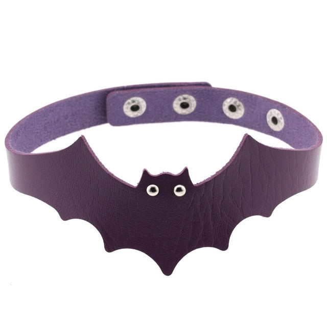 Purple faux leather bat wing choker shown fastened in a circle, with a scalloped front, pointed ears and two silver-tone eyelet eyes. The adjustable snap positions are visible across the back.