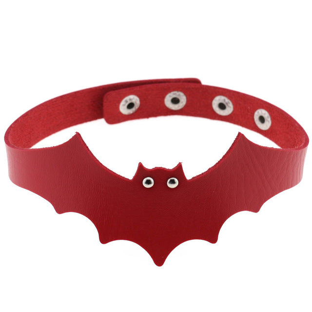 Red faux leather bat wing choker shown fastened in a circle, with a scalloped front, pointed ears and two silver-tone eyelet eyes. The adjustable snap positions are visible across the back.