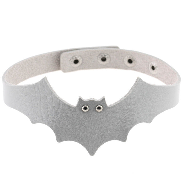 Silver faux leather bat wing choker shown fastened in a circle, with a scalloped front, pointed ears and two silver-tone eyelet eyes. The adjustable snap positions are visible across the back.