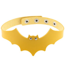 Yellow faux leather bat wing choker shown fastened in a circle, with a scalloped front, pointed ears and two silver-tone eyelet eyes. The adjustable snap positions are visible across the back.