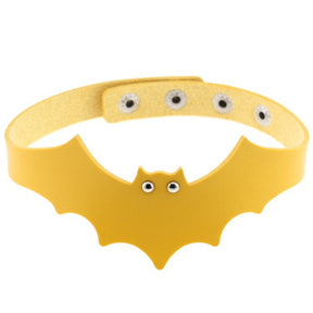 Yellow faux leather bat wing choker shown fastened in a circle, with a scalloped front, pointed ears and two silver-tone eyelet eyes. The adjustable snap positions are visible across the back.