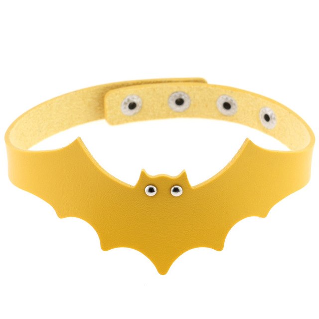 Yellow faux leather bat wing choker shown fastened in a circle, with a scalloped front, pointed ears and two silver-tone eyelet eyes. The adjustable snap positions are visible across the back.