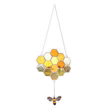 Bee and honeycomb stained glass hanging in the Small Bee design with a bee suspended below amber honeycomb.