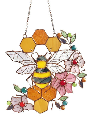 Bee and honeycomb stained glass hanging with a large bee, pink flowers and amber hexagons, front view.