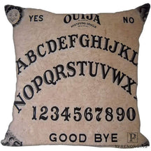 Muted beige square Ouija cushion cover with classic black alphabet rows, numbers, sun-and-moon faces and Good Bye lettering.
