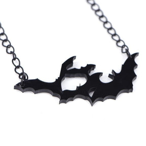 Angled close-up of the black acrylic bat pendant, revealing the cutout spaces and thickness of the bat silhouettes.