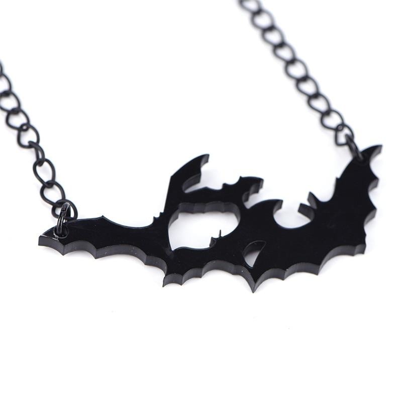 Angled close-up of the black acrylic bat pendant, revealing the cutout spaces and thickness of the bat silhouettes.