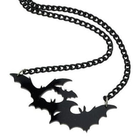 Black bat pendant necklace arranged with the matching chain looped above the overlapping wing shapes.