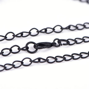 Close-up of the black necklace chain, lobster clasp and extension links on a white background.