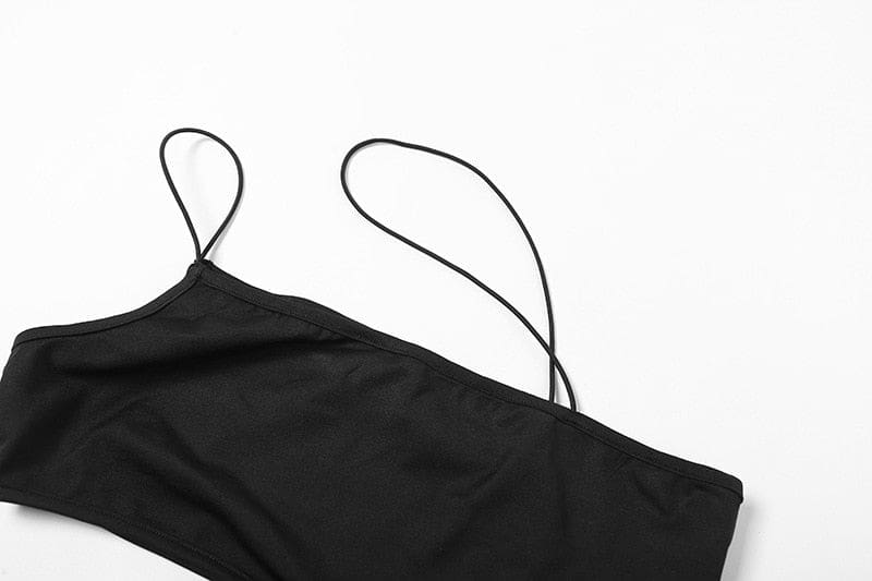 Close-up of the black crop top's opaque bust panel and two narrow straps, including the long diagonal strap that creates the asymmetric neckline.