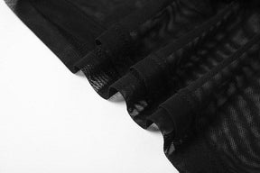 Close-up of the black mesh fabric and finished seams on the crop top and sleeve set, with the transparent material folded over a white background.