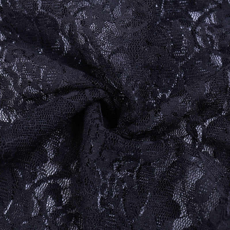 Close-up of folded black floral lace from the bolero, showing the fine mesh and flower motifs.