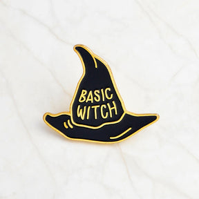 Black Basic Witch hat pin with gold-tone lettering, a pointed crown and a curved brim on white.