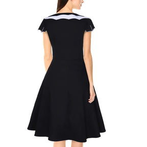 Black bat-collar dress worn from the back, showing the white collar detail and plain flared skirt.
