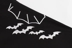 Close-up of white bats and a large outlined wing printed across the front of the black dress skirt.