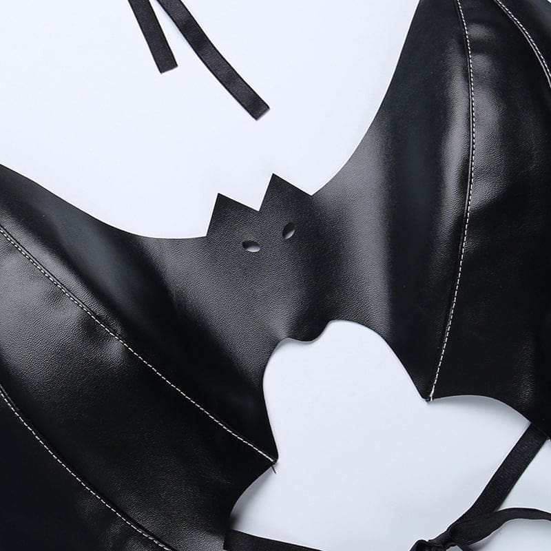 Close view of the black bralette’s bat face, with pointed ears and two tiny eye cutouts between stitched wings.