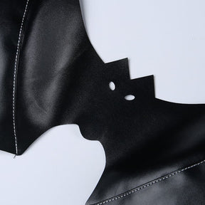 Macro view of the bat bralette’s small eye openings and pointed ears, with stitching and a glossy black finish visible nearby.