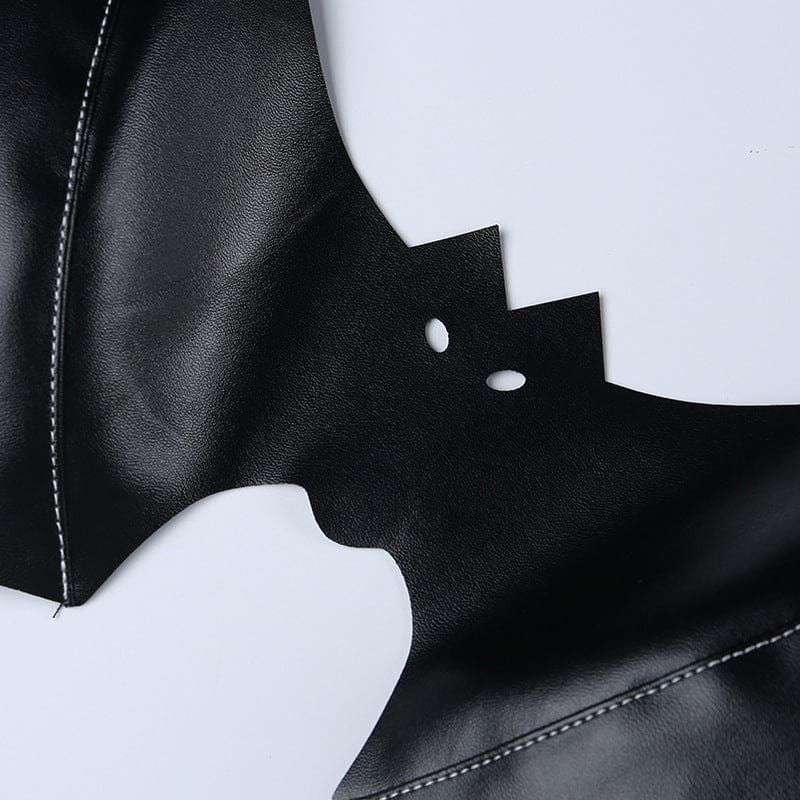 Macro view of the bat bralette’s small eye openings and pointed ears, with stitching and a glossy black finish visible nearby.