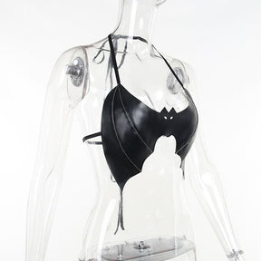 Side view of the bat-shaped bralette on a clear mannequin, showing the curved front panel and narrow straps around the neck and back.