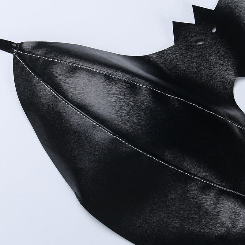 Detail of a glossy black bralette wing laid on white, with curved rows of stitching leading toward the pointed tip.