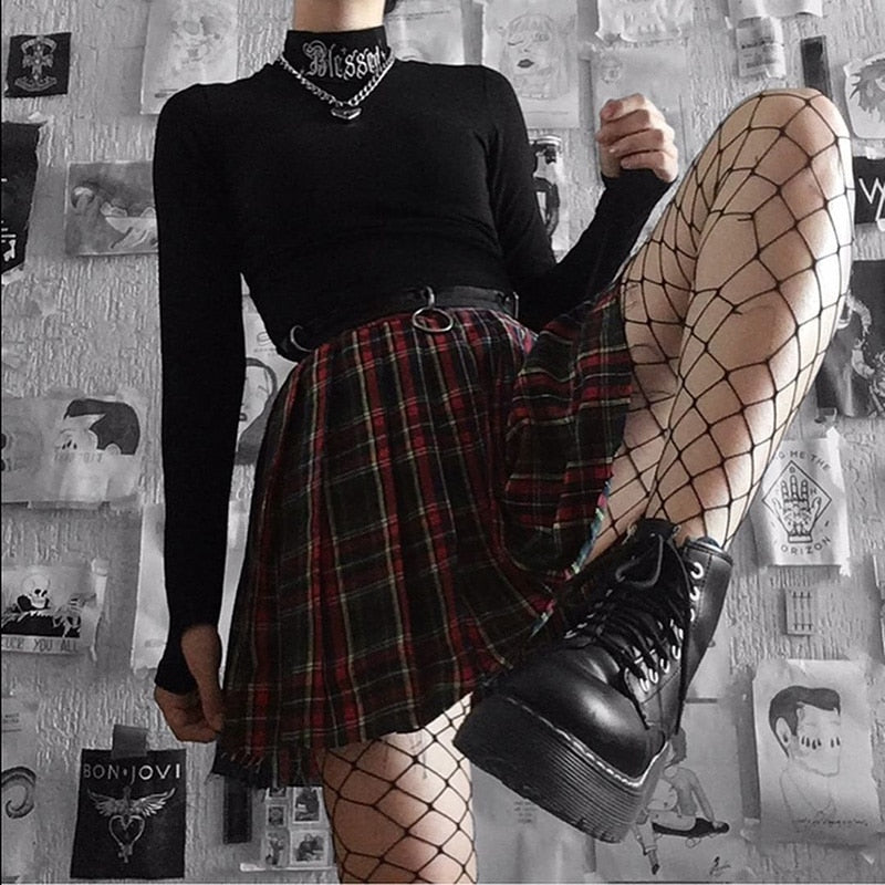 Black Blessed embroidered turtleneck crop top styled with a red plaid skirt and fishnet tights.