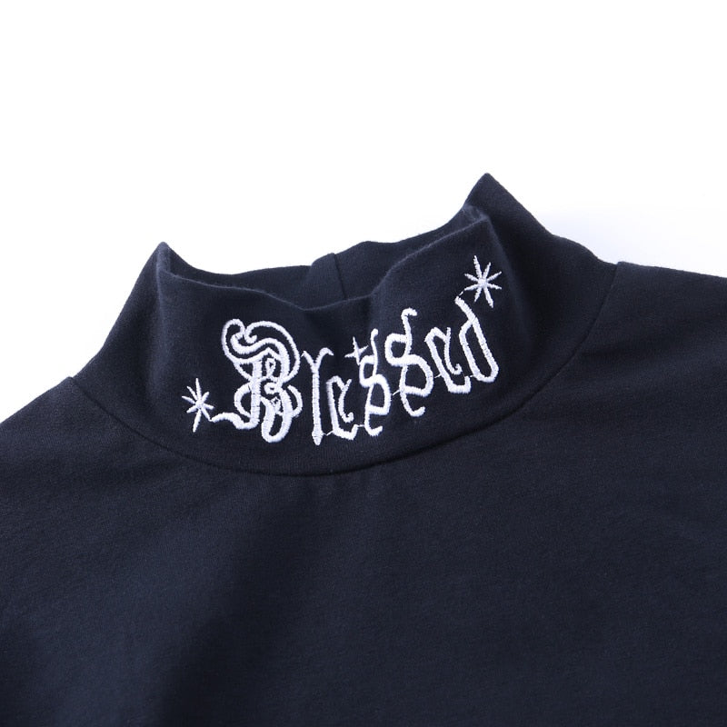 Black Blessed embroidered turtleneck crop top with a close view of the white Blessed collar embroidery.