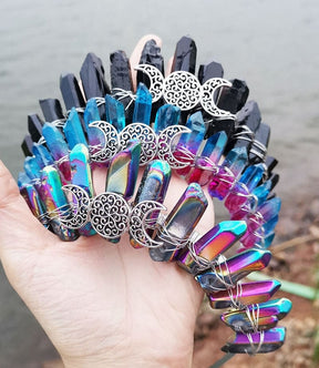 Black, blue-pink and metallic rainbow crowns shown as a trio, each with a silver-tone lunar centre beneath pointed crystals.