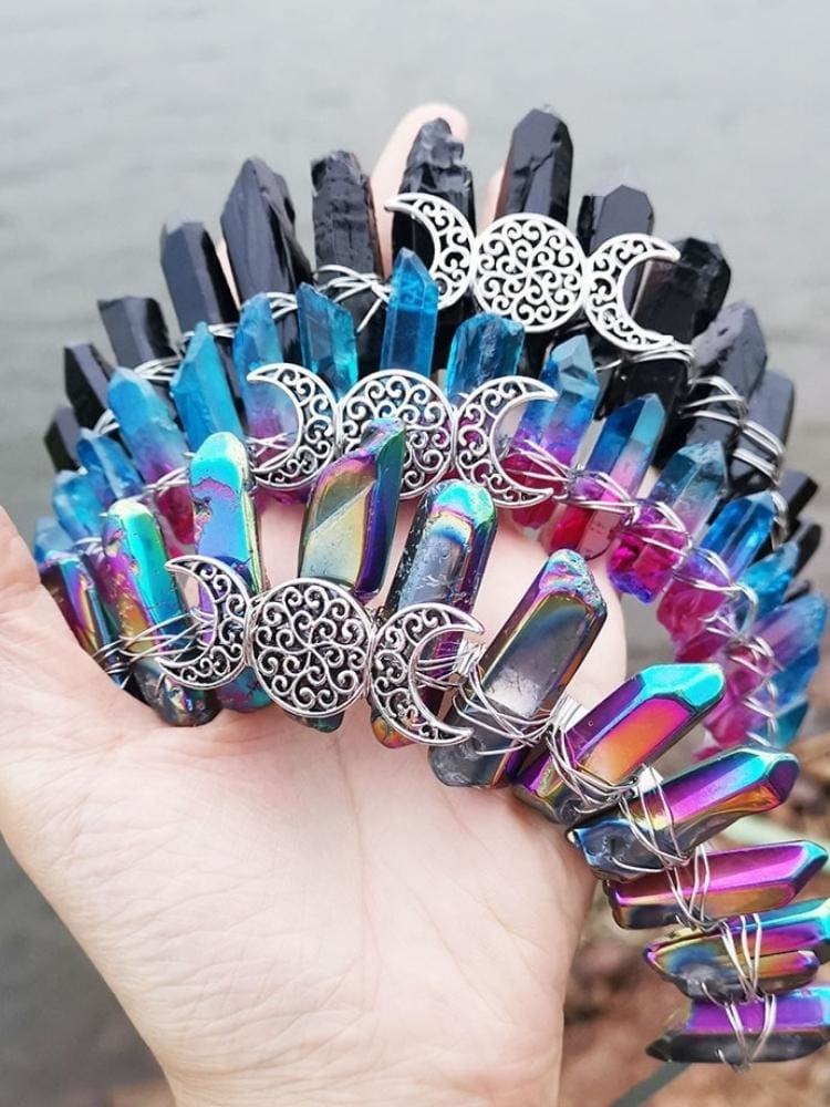 Three triple moon crystal crowns grouped on white, comparing black, blue-pink and metallic rainbow points with silver-tone wirework.