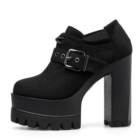 Side profile of a black lace-up buckle bootie with a rounded closed toe, deep front platform and tall block heel.