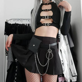 Black cutout buckle crop top styled with a short chain-trimmed skirt and fishnet tights, showing the cropped hem and long sleeves.