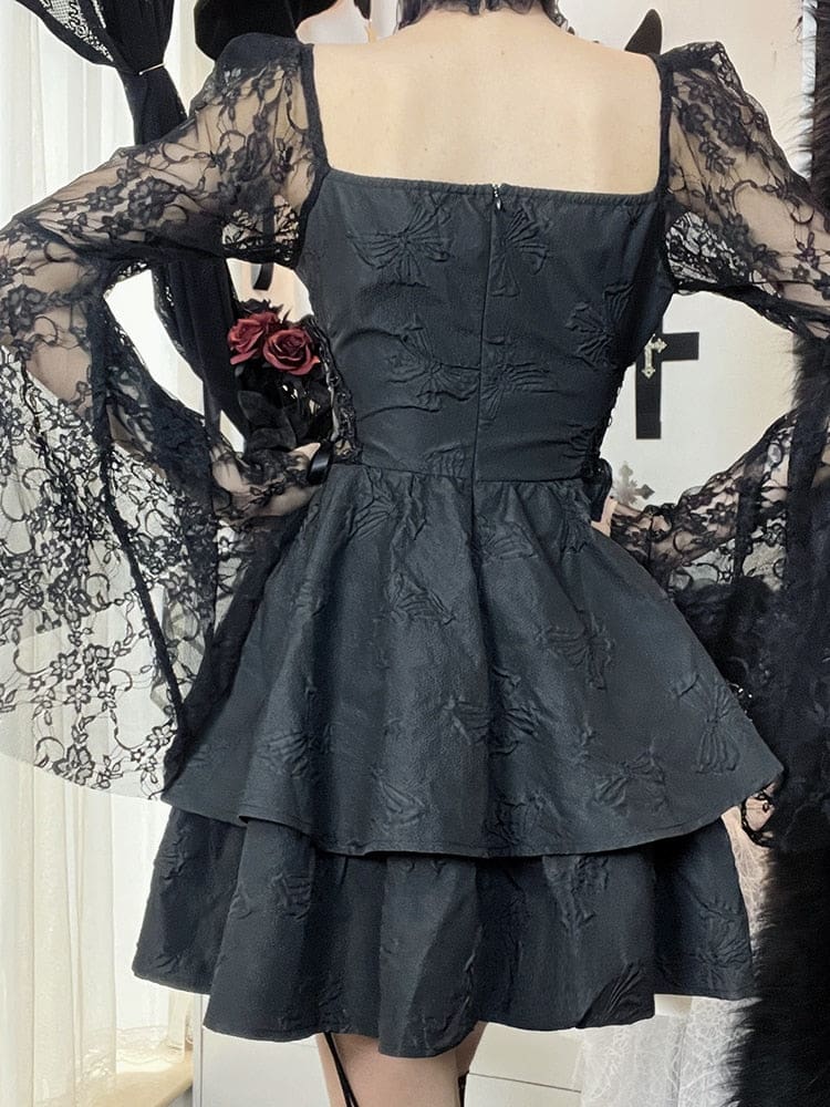 Rear view of the black butterfly dress on a model, showing the fitted back of the bodice and layered skirt between the long lace sleeves.
